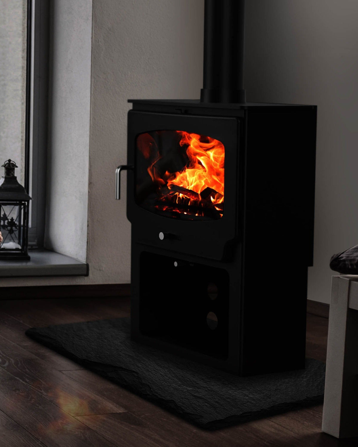A DEFRA exempt wood burning stove alight on a slate hearth