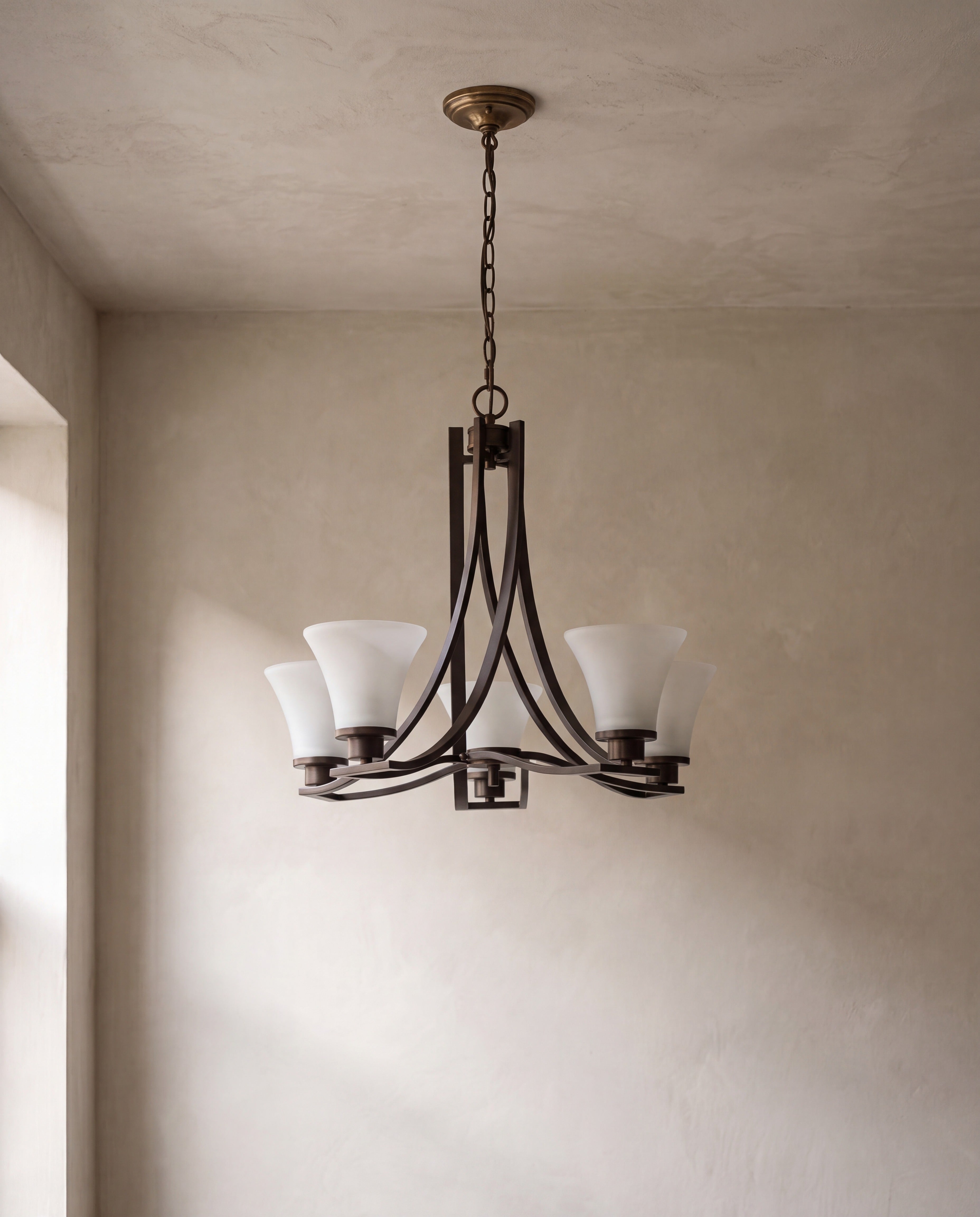 Bronze Five-Light Chandelier with White Shades — on limewash plaster