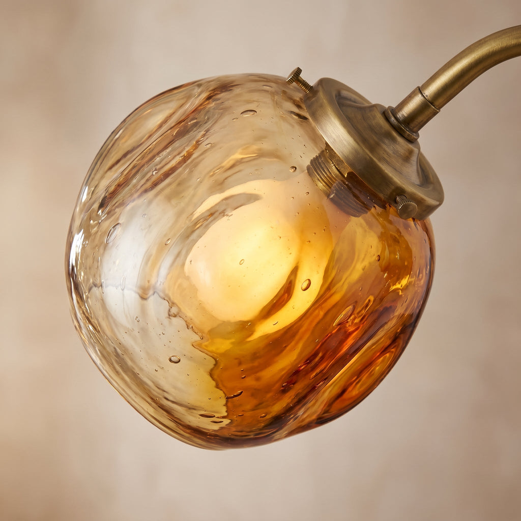 Close-up of hand-blown amber glass shade showing organic texture and artisan bubbles
