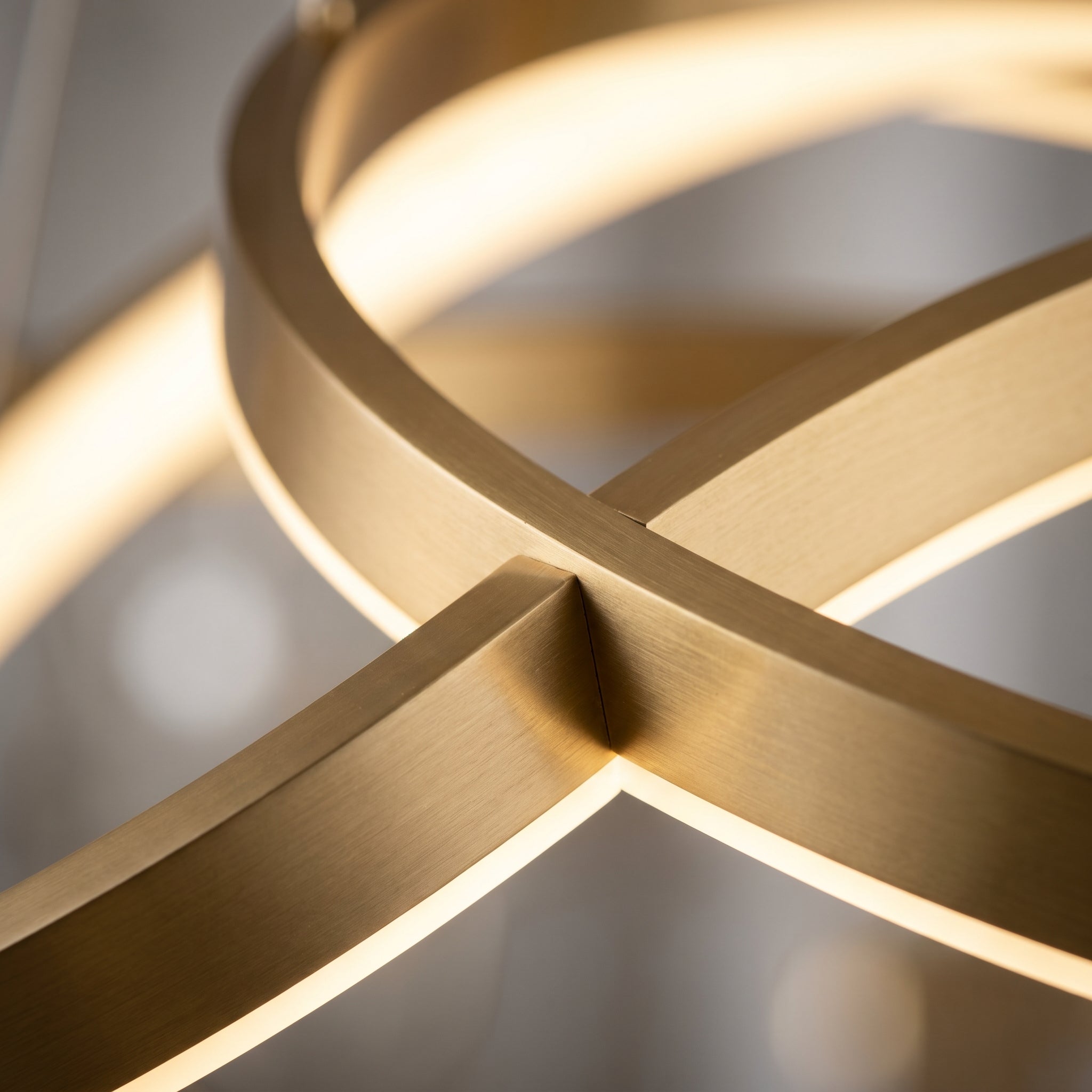 Close-up detail of gold ring intersection showing brushed satin finish and integrated LED strip