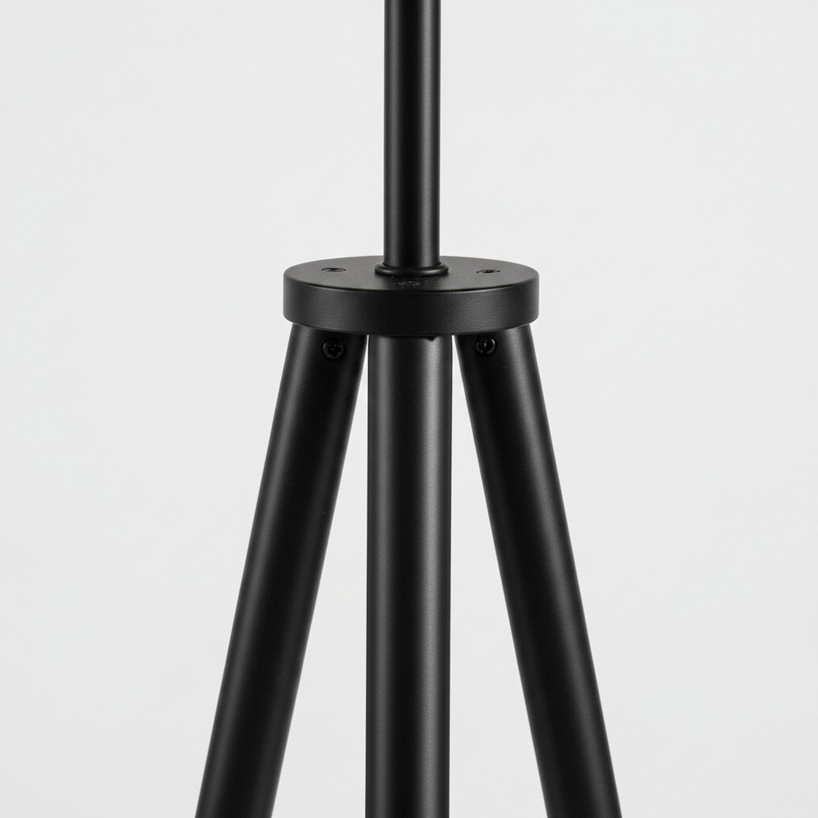 Close-up detail of black tripod floor lamp leg junction and hardware finish