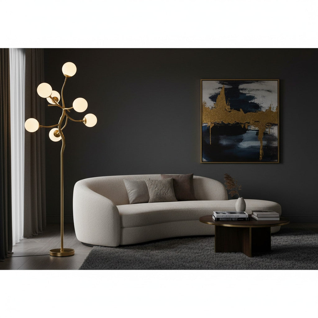 Gold sculptural branch floor lamp in modern living room with dark walls and curved sofa