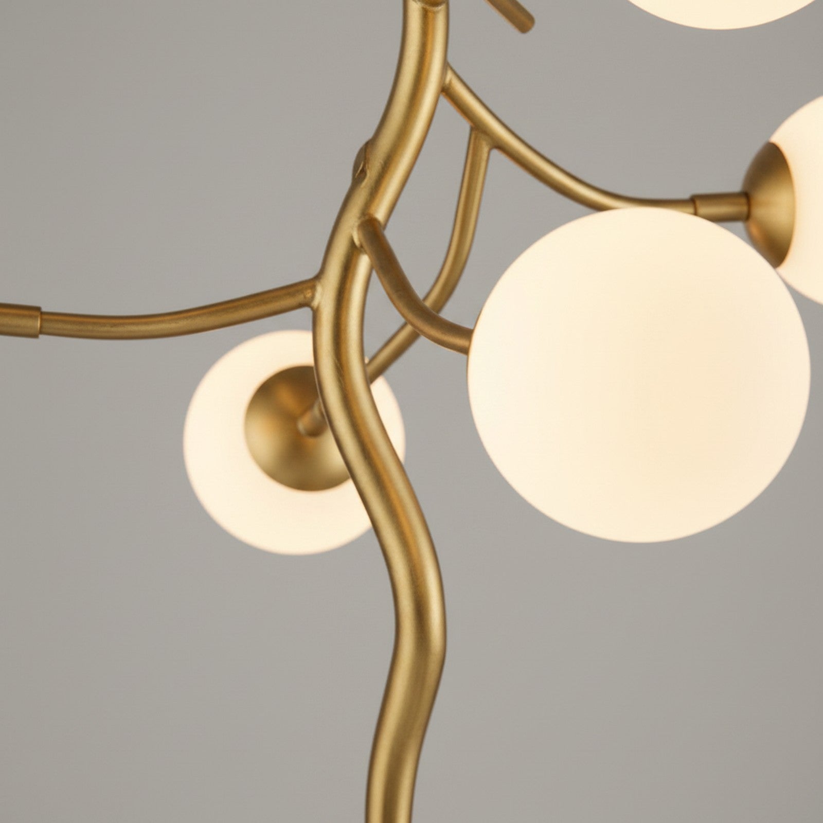 Close-up detail of gold branch LED lamp showing organic branch shapes and LED globe