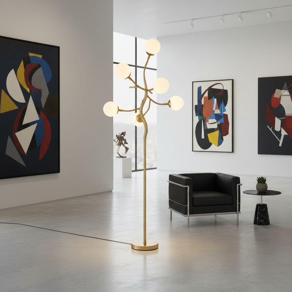 Gold sculptural branch LED floor lamp as statement piece in art gallery lobby setting