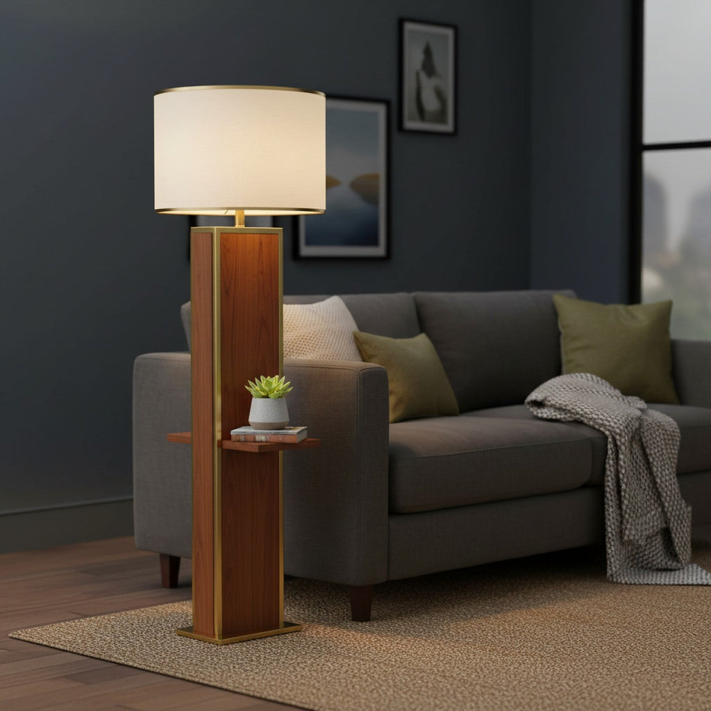 Walnut column floor lamp next to sofa with plant and book on built-in shelf