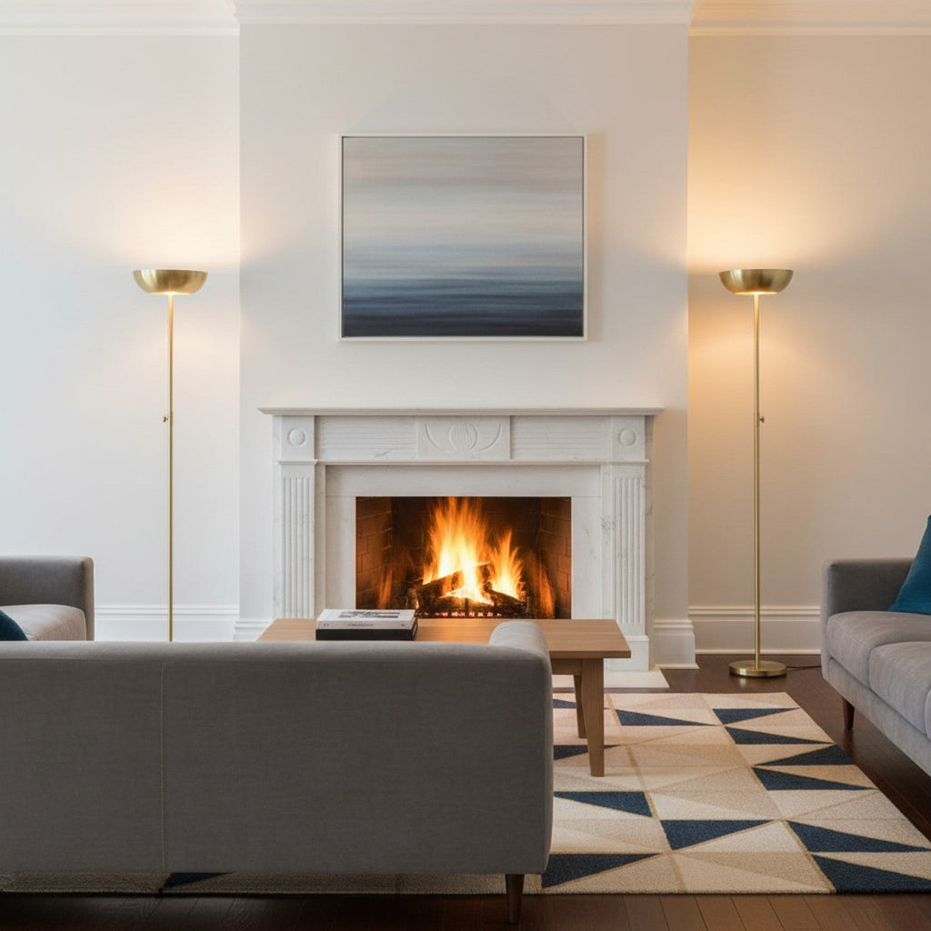 Brass torchiere lamp flanking fireplace in traditional-modern living room with uplight
