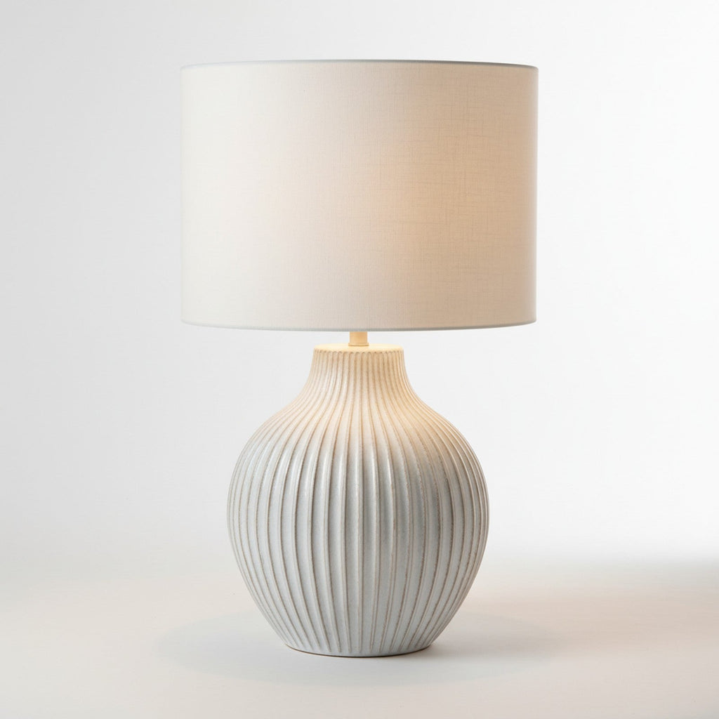 Oversized white ceramic textured table lamp with ridged surface and linen drum shade
