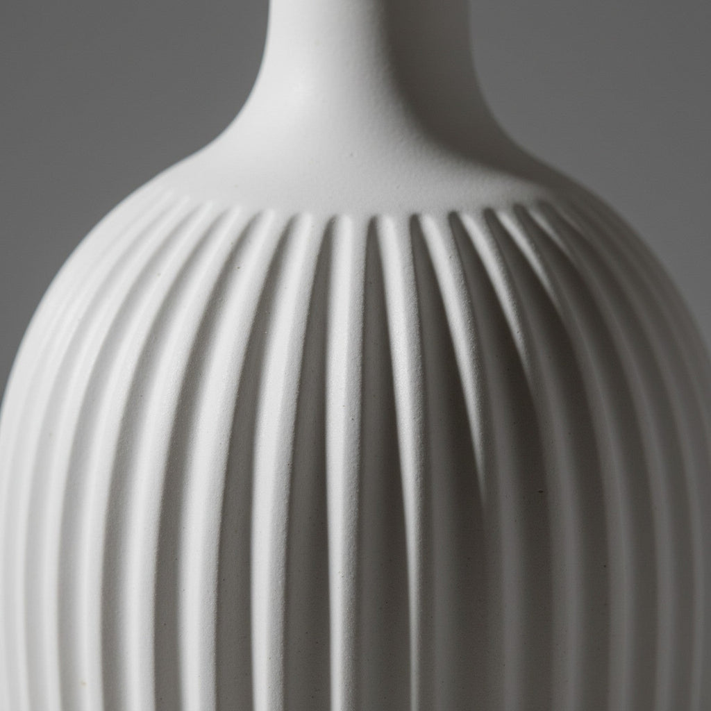 Close-up of white ceramic ridged texture with matte glaze and shadow detail