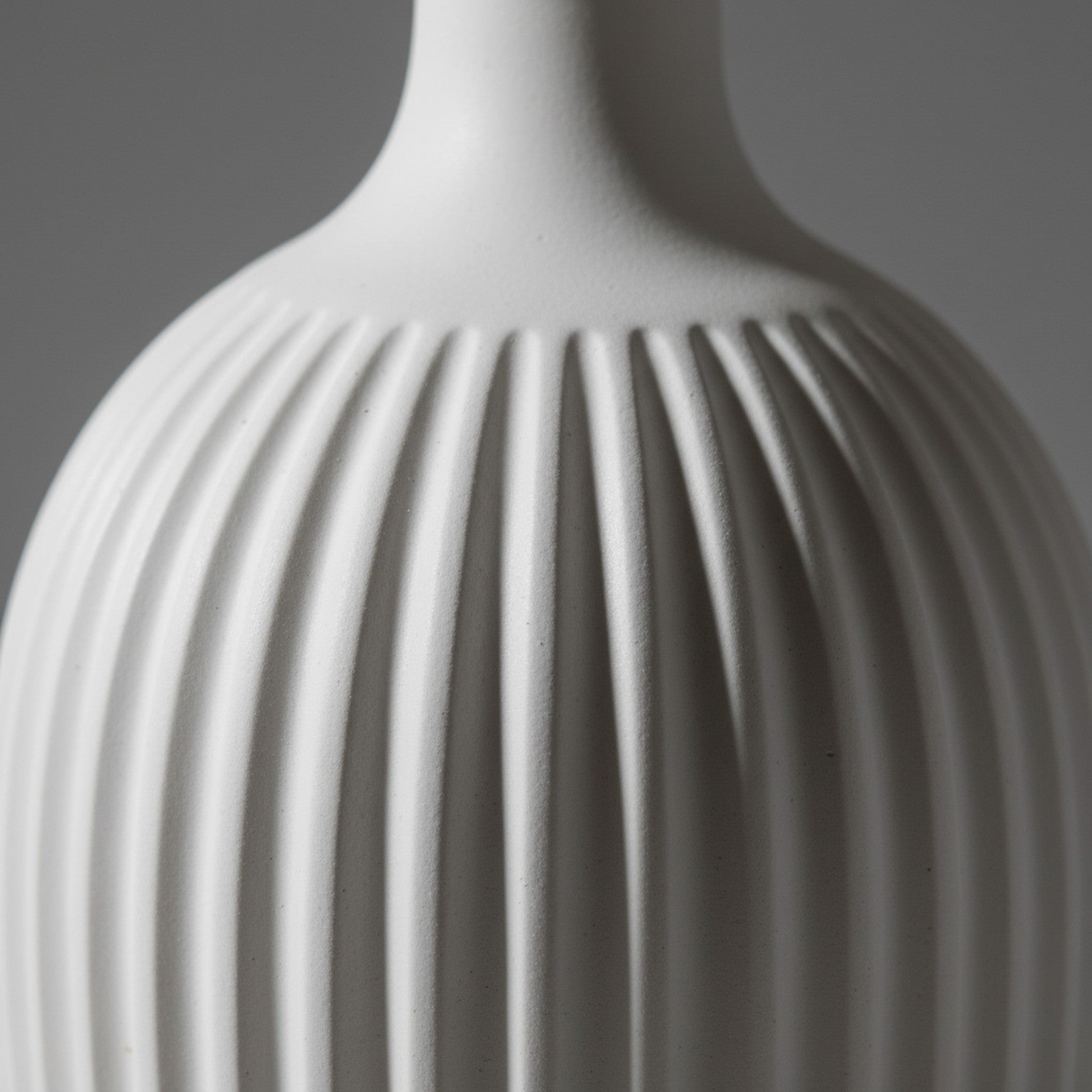 Close-up of white ceramic ridged texture with matte glaze and shadow detail