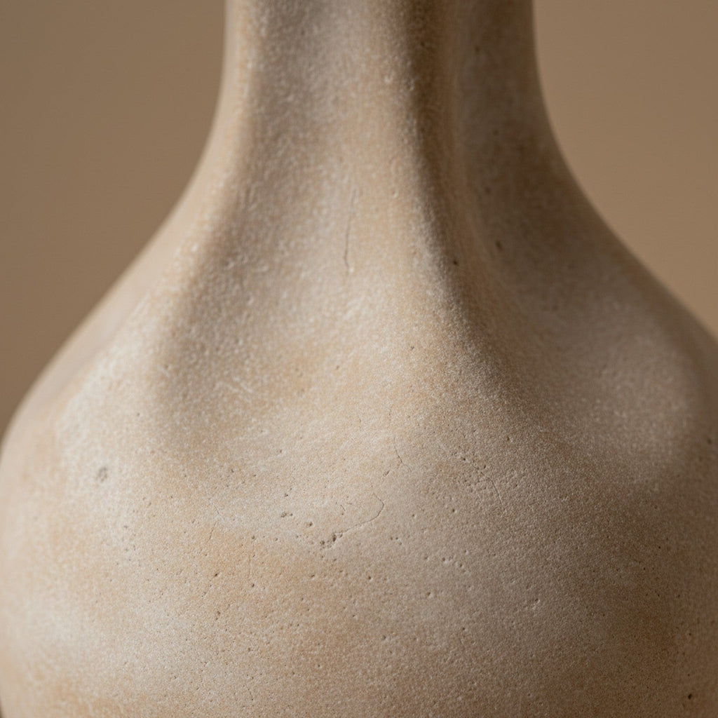 Close-up of cast stone lamp surface showing chalky matte finish and subtle beige color variations