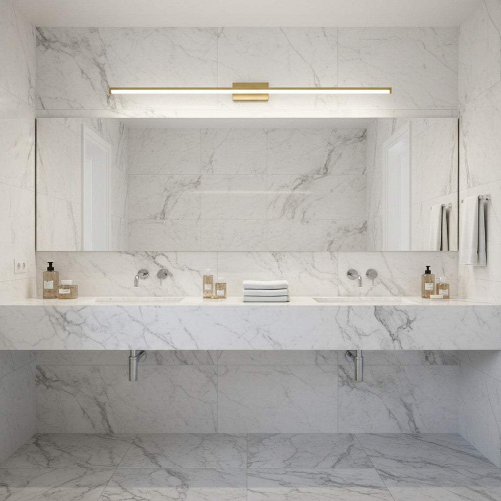 Brass LED linear wall light above bathroom vanity mirror providing even illumination