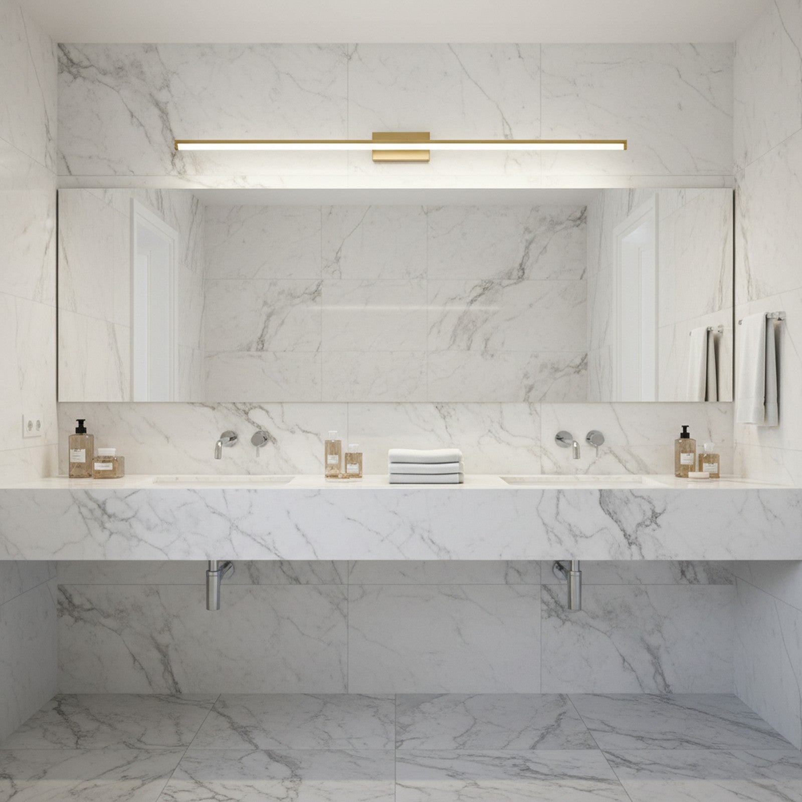 Brass LED linear wall light above bathroom vanity mirror providing even illumination