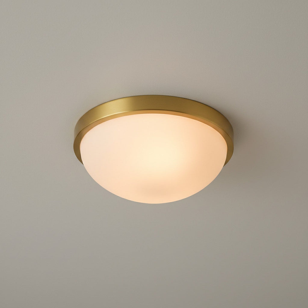 Flush mount ceiling light viewed from below showing full circular opal dome and brass ring