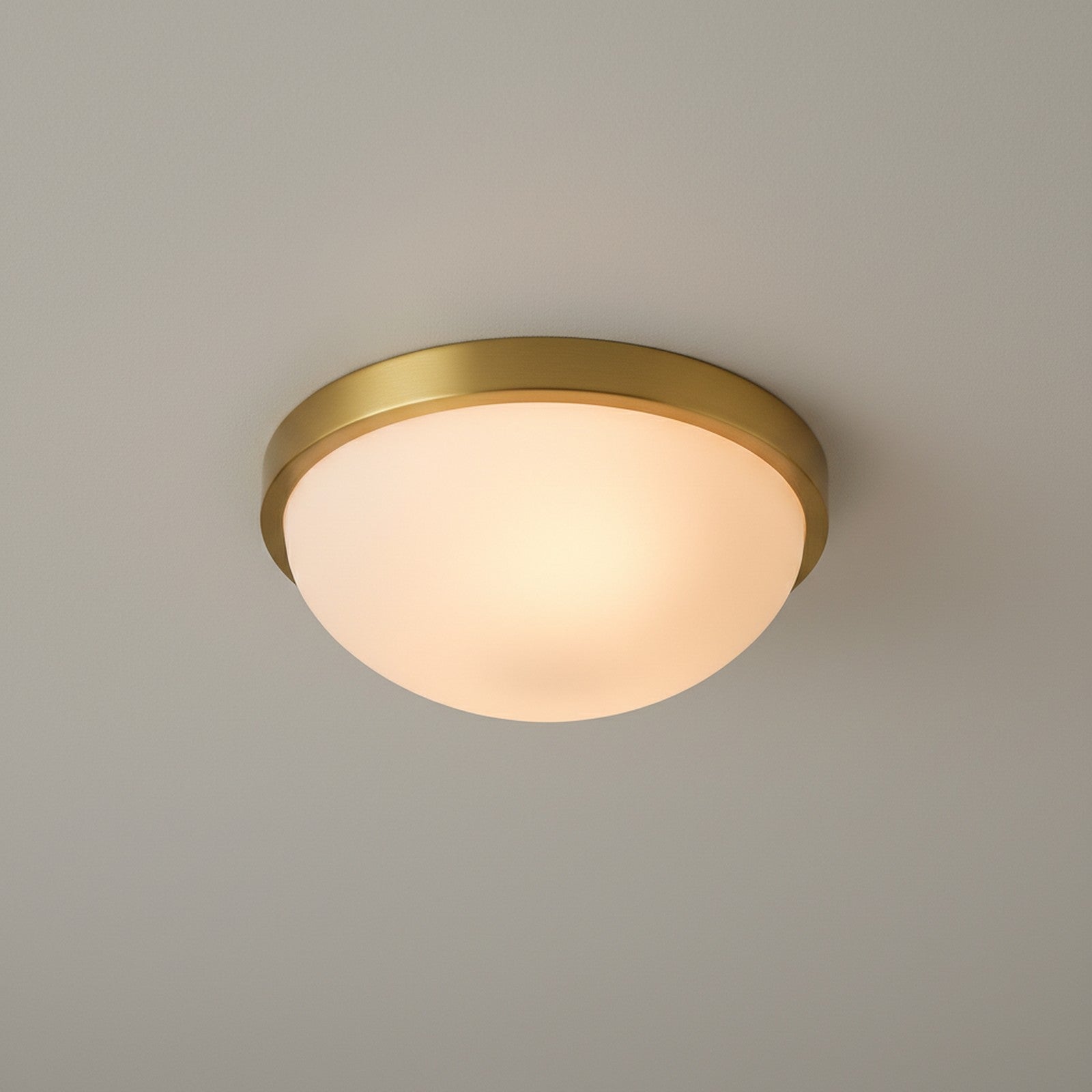 Flush mount ceiling light viewed from below showing full circular opal dome and brass ring